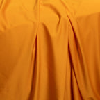 Close-up of orange fabric with folds.