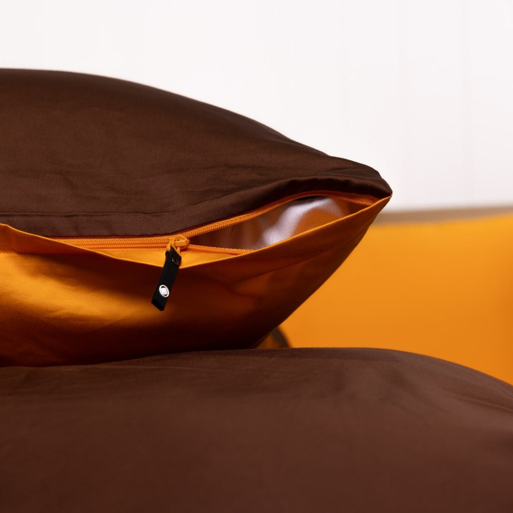 Brown and orange fabric with a zipper on a white background.