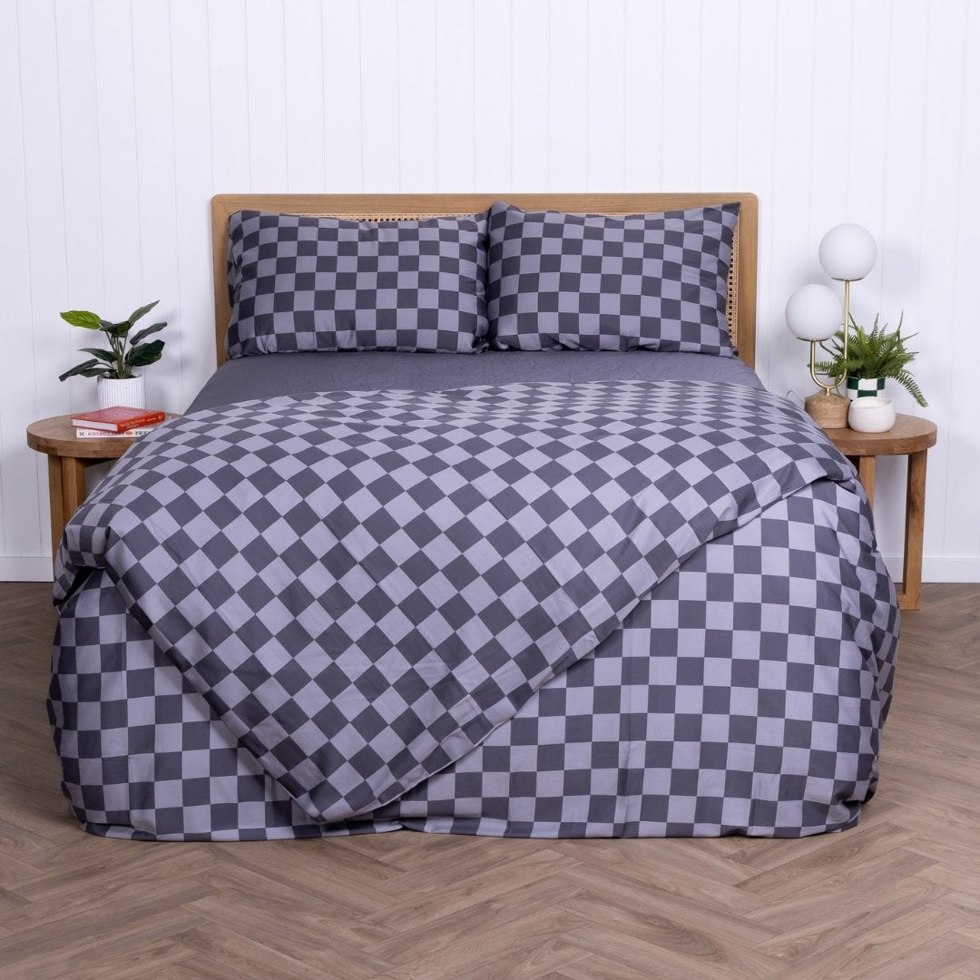 Checkered bedspread on a bed with matching pillows in a room setting.