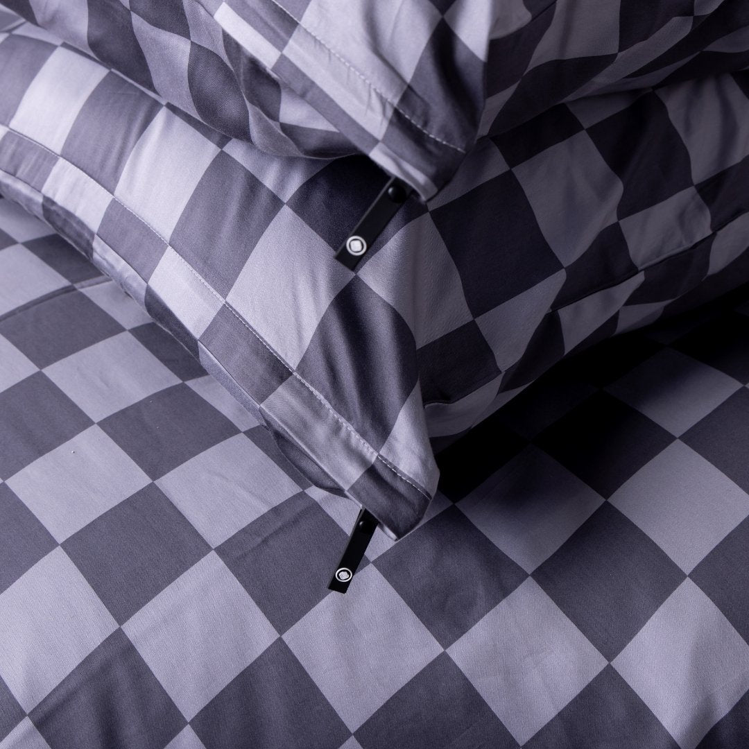 Close-up of a checkered fabric pillowcases with a pattern of dark grey and light grey squares.