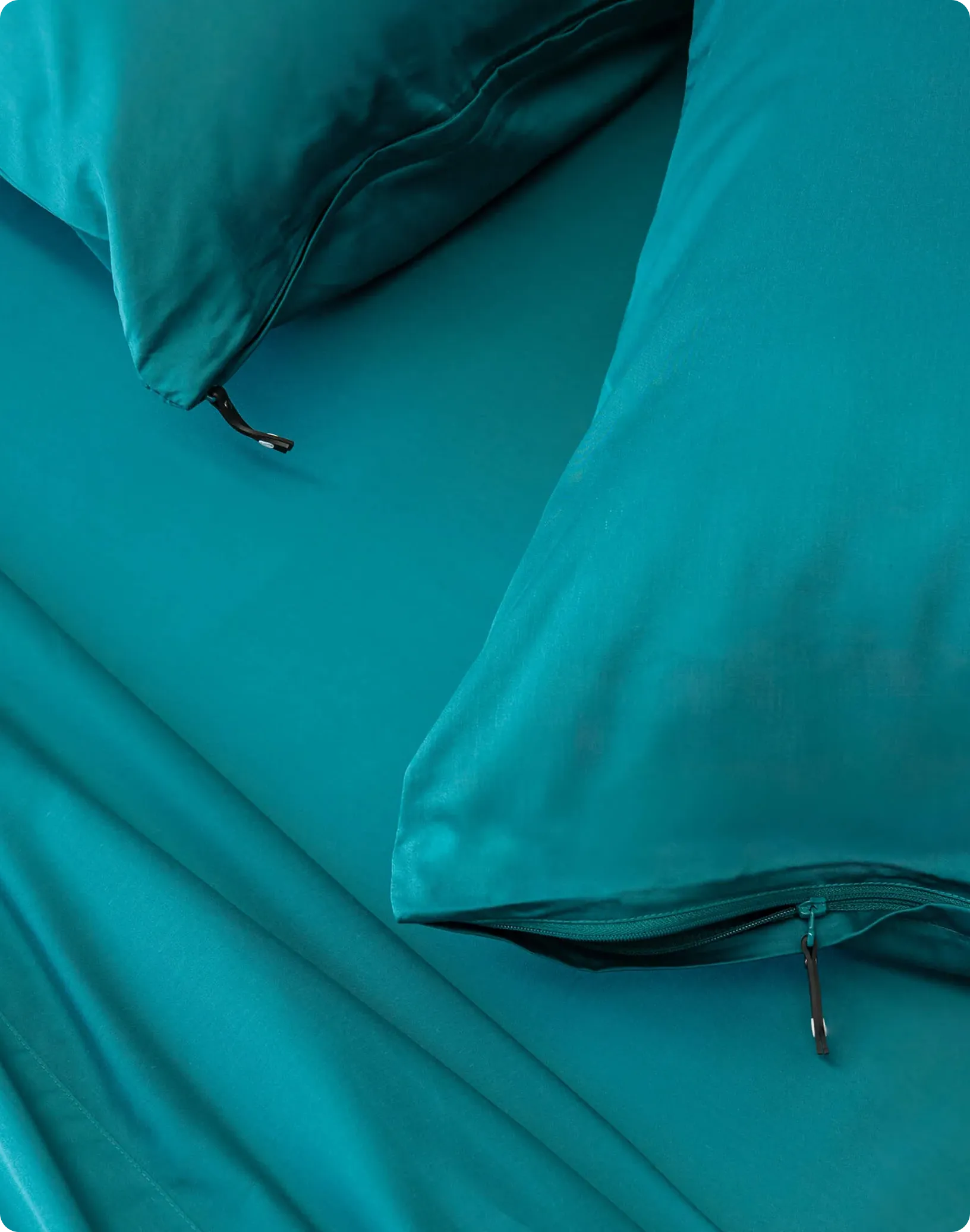 Teal bedding set with two pillows on a bed.