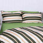 Striped green and white bedding set with pillows on a bed.