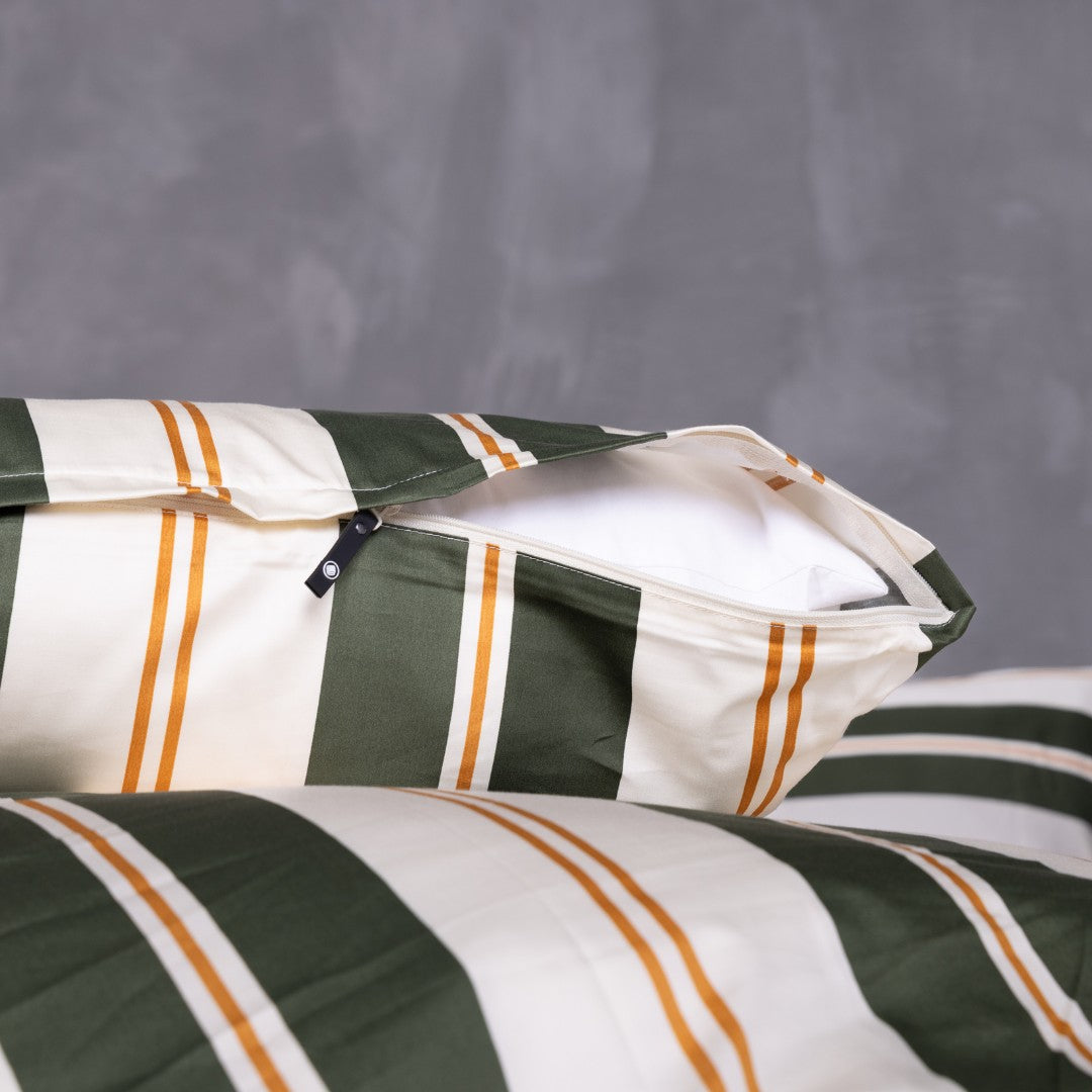 Striped pillowcases with green, orange, and white pattern on a gray background