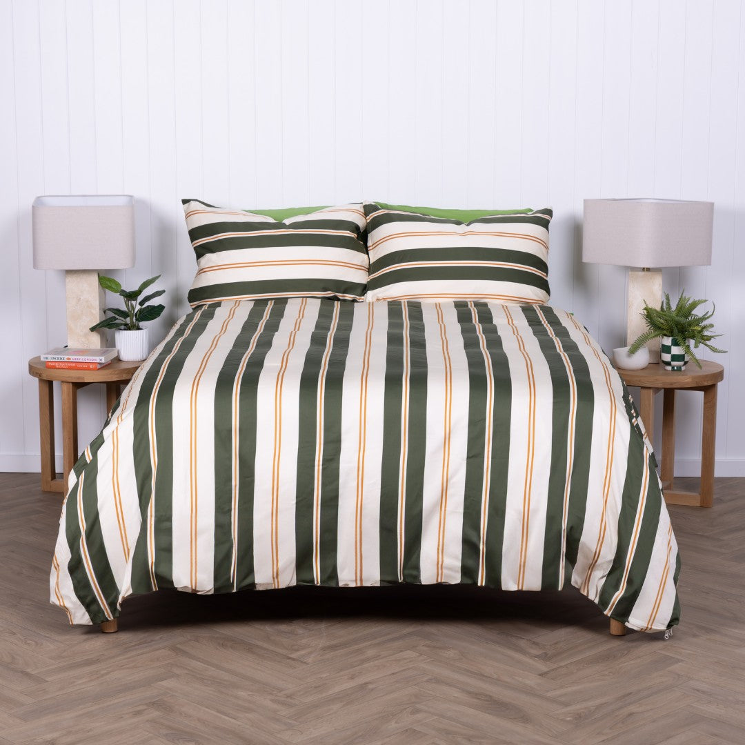 Striped bedspread on a bed with matching pillows in a bedroom setting.