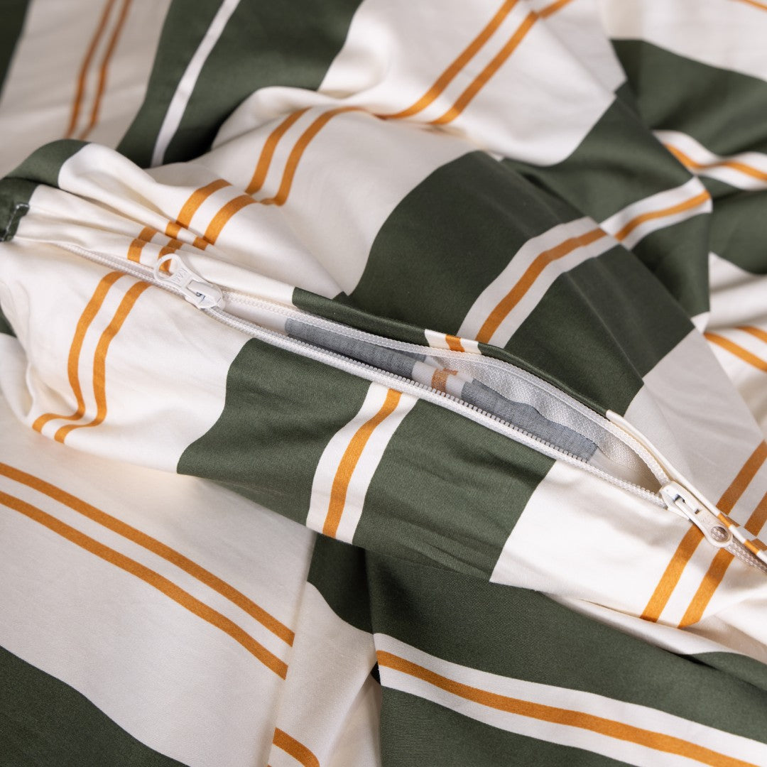 Close-up of a duvet cover with green, white, and orange stripes and a zipper.
