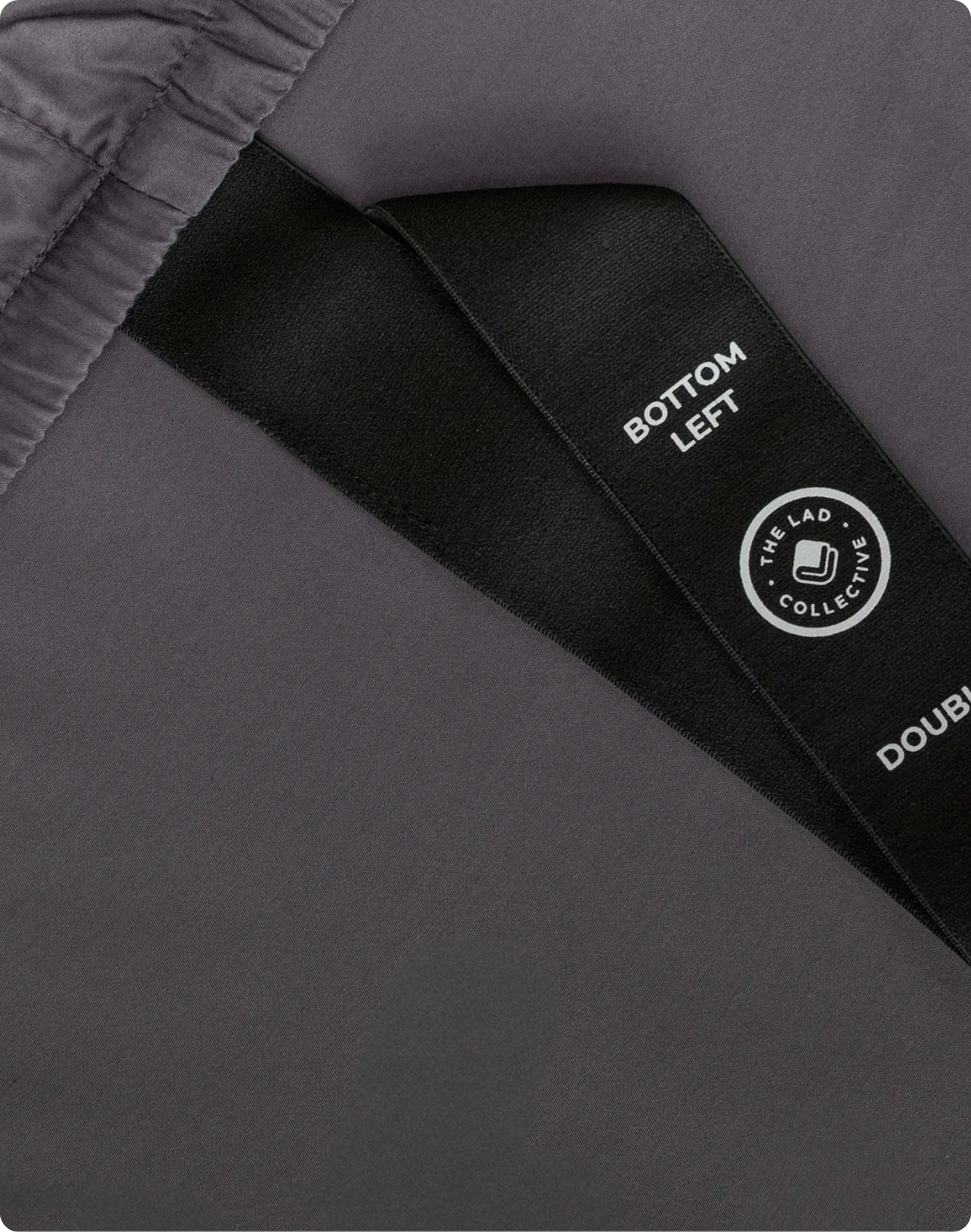Gray fabric with a black label and 'The Sad Collective' logo.