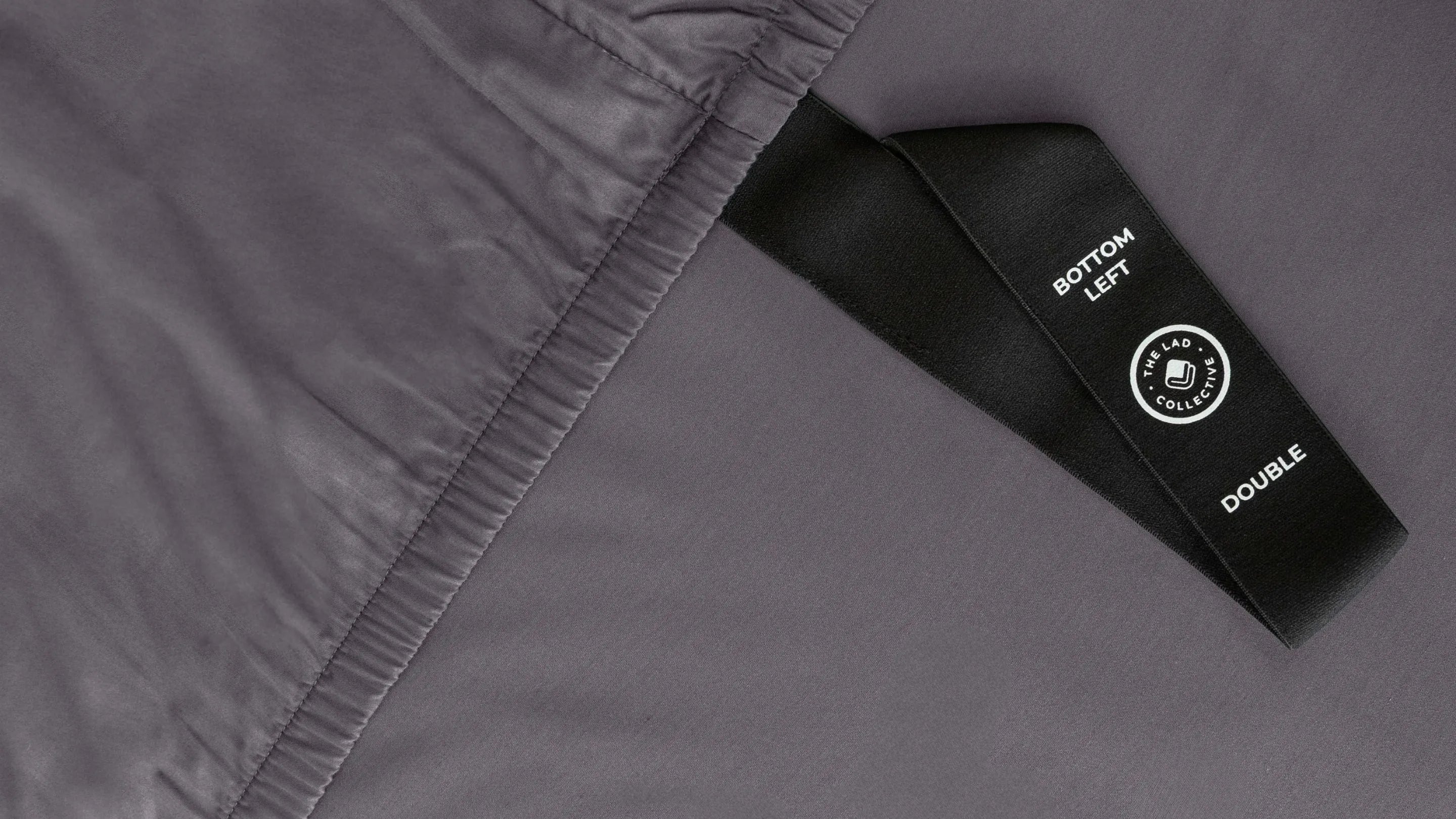 Close-up of a gray garment with a black label on a matching gray background