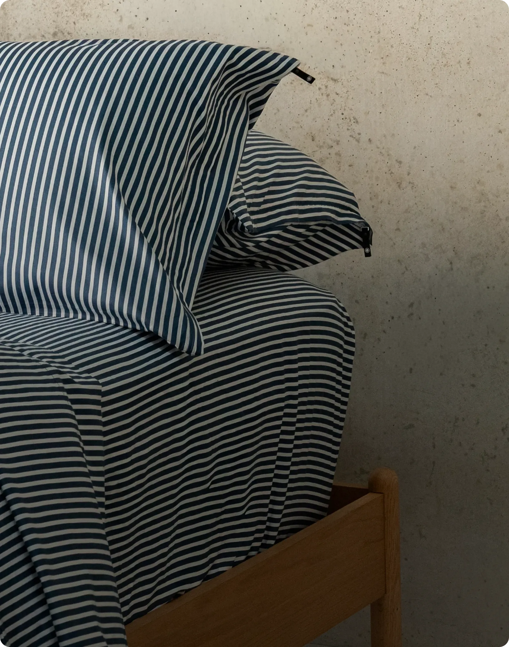 Striped bedding set on a bed with a neutral wall background