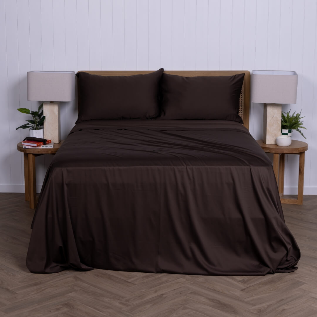 Brown bed sheets & pillowcases on a bed with matching pillows in a minimalistic bedroom setting.