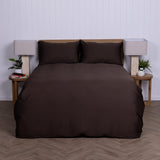 Brown duvet cover set on a bed with matching pillows against a white wall.