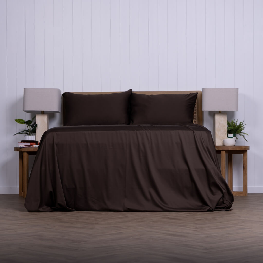 Brown bed sheets on a bed with matching pillows in a minimalistic bedroom setting.