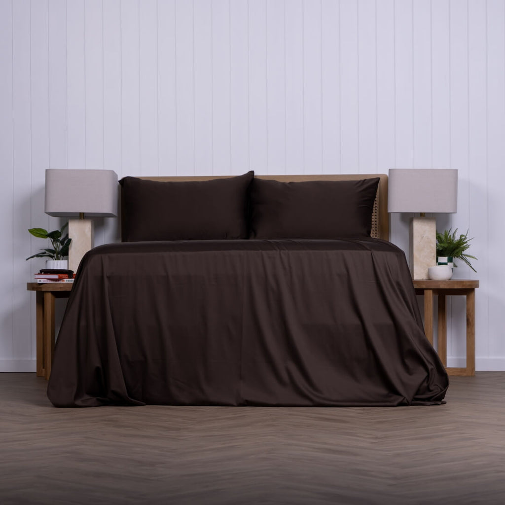 Brown bed sheets on a bed with matching pillows in a minimalistic bedroom setting.